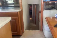 Interior of a 1999 Viking 58 EB yacht, featuring a cozy hallway and wooden cabinetry.