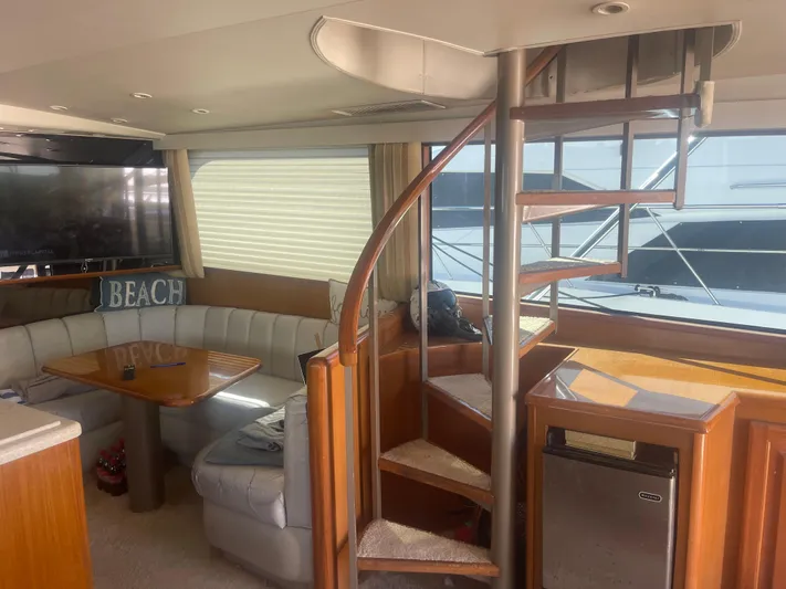  Yacht Photos Pics Luxurious 1999 Viking 58 EB yacht interior with spiral staircase and cozy seating area.