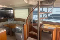 Luxurious 1999 Viking 58 EB yacht interior with spiral staircase and cozy seating area.