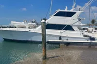 1999 Viking 58 EB yacht docked in a marina under a clear blue sky.
