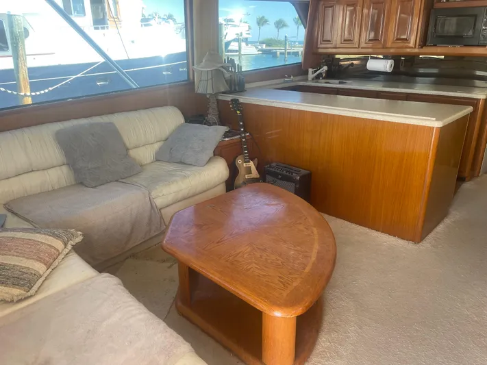  Yacht Photos Pics Cozy interior of 1999 Viking 58 EB yacht with sofas, guitar, and wooden table.