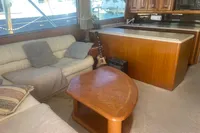 Cozy interior of 1999 Viking 58 EB yacht with sofas, guitar, and wooden table.