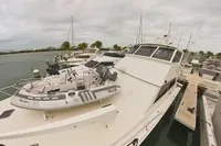 1999 Viking 58 yacht docked with inflatable boat on deck, overcast sky.