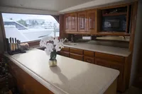 Luxurious kitchen interior of a 1999 Viking 58 yacht with wooden cabinets and countertop.