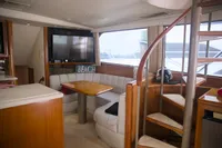 Interior of 1999 Viking 58 yacht with cozy seating and spiral staircase.