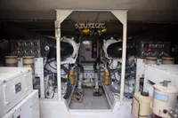 Engine room of a 1999 Viking 58 yacht, showcasing dual engines and control panels.