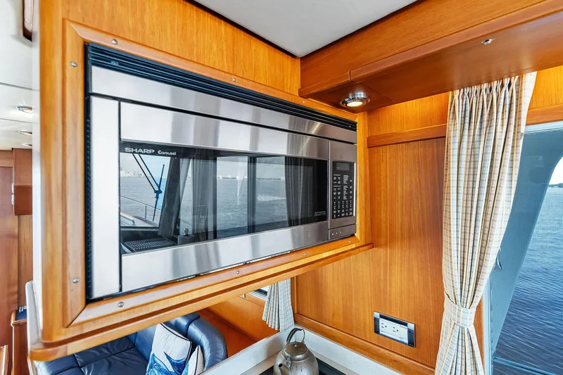Draagen Yacht Photos Pics Microwave in 2006 Grand Banks Europa 47 yacht interior, featuring wood paneling and window view.