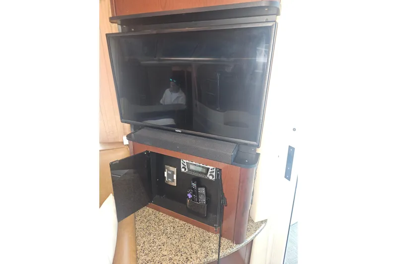 Sea Trials Yacht Photos Pics Entertainment system inside 2007 Sea Ray 44 Sedan Bridge yacht, featuring a Vizio TV and control panel.