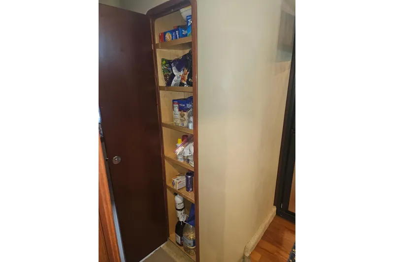 Sea Trials Yacht Photos Pics Pantry shelves inside a 2007 Sea Ray 44 Sedan Bridge, stocked with various food items.