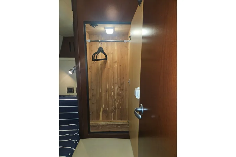 Sea Trials Yacht Photos Pics 2007 Sea Ray 44 Sedan Bridge interior closet with wooden finish and hangers.