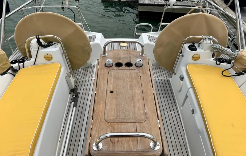Charisapa Yacht Photos Pics Cockpit of 2012 Jeanneau 50 DS sailboat with yellow cushions and wooden table.