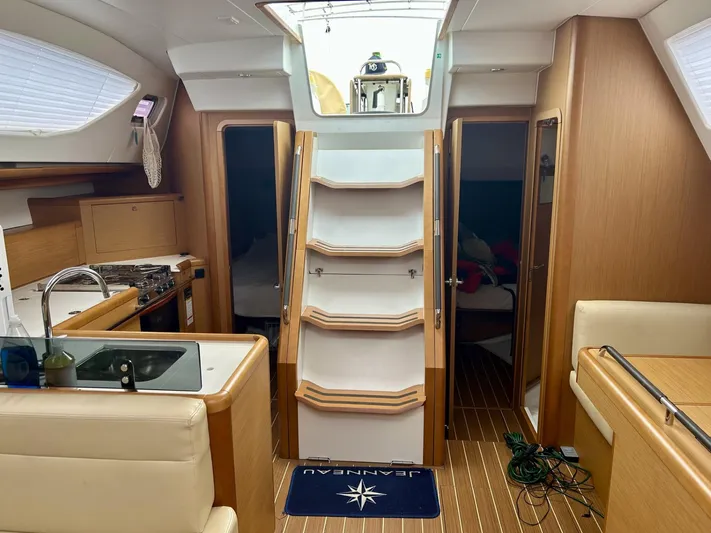Charisapa Yacht Photos Pics Interior of 2012 Jeanneau 50 DS yacht, featuring kitchen, stairs, and cozy cabin spaces.