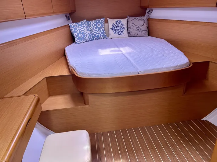 Charisapa Yacht Photos Pics Interior cabin of 2012 Jeanneau 50 DS yacht with cozy bed and decorative pillows.