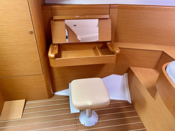 Charisapa Yacht Photos Pics Interior of 2012 Jeanneau 50 DS yacht with wooden finish and cushioned stool.