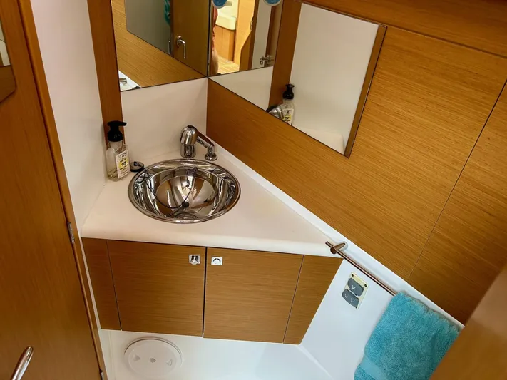 Charisapa Yacht Photos Pics Compact bathroom in 2012 Jeanneau 50 DS yacht with modern sink and wooden cabinetry.
