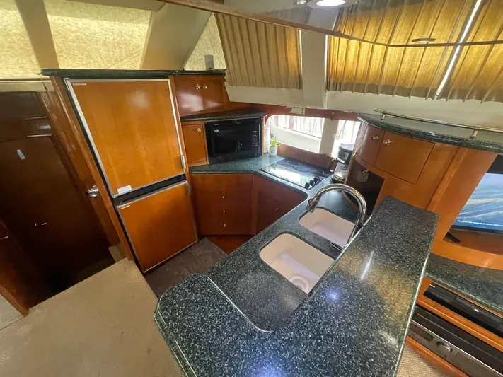  Yacht Photos Pics Interior of 2000 Carver 506 Motor Yacht kitchen with wood cabinetry and granite countertops.