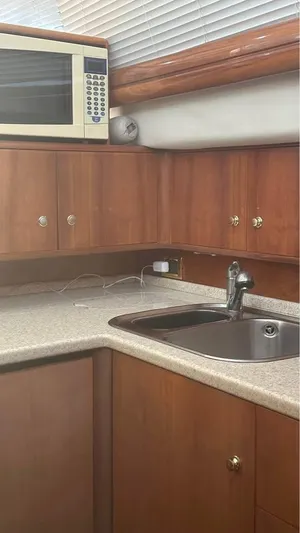 Nirvana Yacht Photos Pics 2004 Cranchi Atlantique 40 Flybridge yacht kitchen with wood cabinets and microwave.