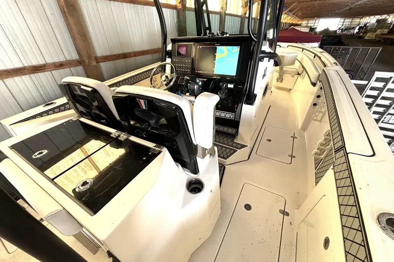 Yacht Photos Pics 2019 Wellcraft 302 Fisherman boat interior with dual consoles and navigation screens in a storage facility.