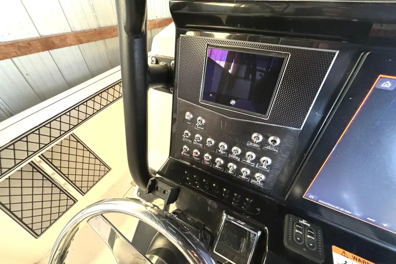  Yacht Photos Pics Control panel of a 2019 Wellcraft 302 Fisherman boat with steering wheel and switches.