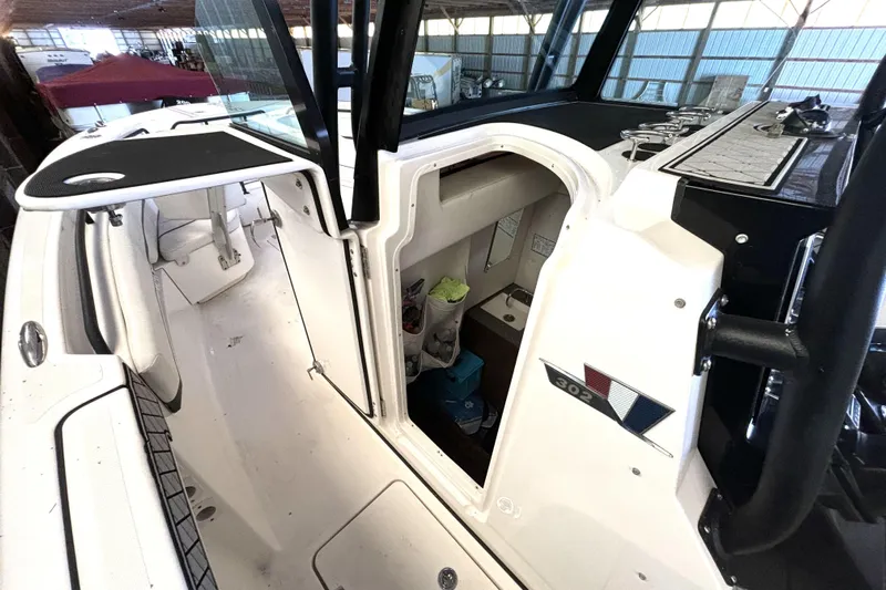  Yacht Photos Pics 2019 Wellcraft 302 Fisherman boat interior with open cabin door, showcasing seating and storage.