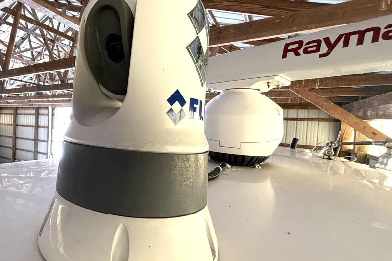  Yacht Photos Pics 2019 Wellcraft 302 Fisherman boat electronics, featuring radar and camera equipment in a wooden boathouse.