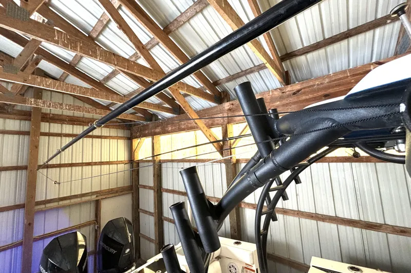  Yacht Photos Pics 2019 Wellcraft 302 Fisherman boat stored in a wooden shed with fishing rods.