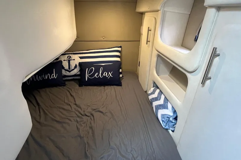  Yacht Photos Pics 2020 Rinker 290 EX cabin interior with cozy bedding and nautical-themed pillows.