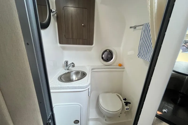  Yacht Photos Pics 2020 Rinker 290 EX boat bathroom with sink, toilet, and storage cabinet.
