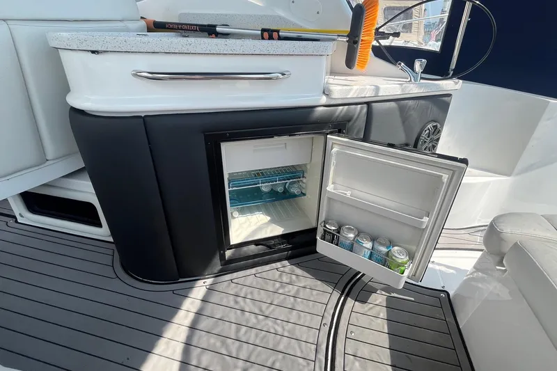  Yacht Photos Pics 2020 Rinker 290 EX boat interior with open mini fridge stocked with drinks.