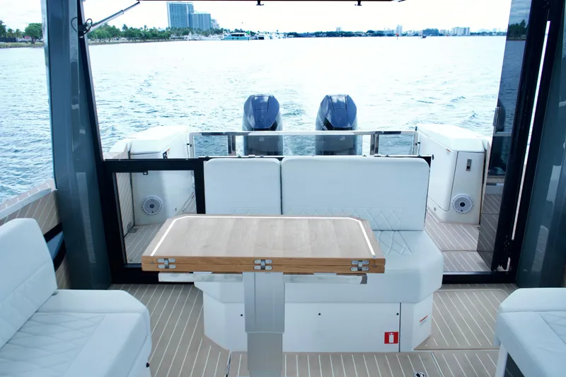 Sierra Tango VI Yacht Photos Pics Interior view of 2025 Saxdor 400 GTO yacht with seating and table, overlooking water.