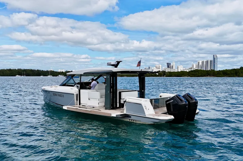 Sierra Tango VI Yacht Photos Pics 2025 Saxdor 400 GTO boat cruising on blue water with city skyline in background.