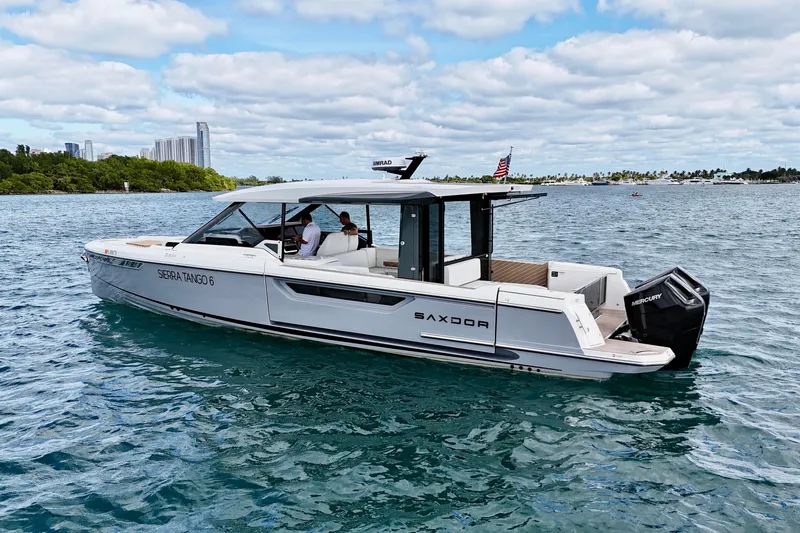 Sierra Tango VI Yacht Photos Pics 2025 Saxdor 400 GTO boat cruising on a sunny day with city skyline backdrop.