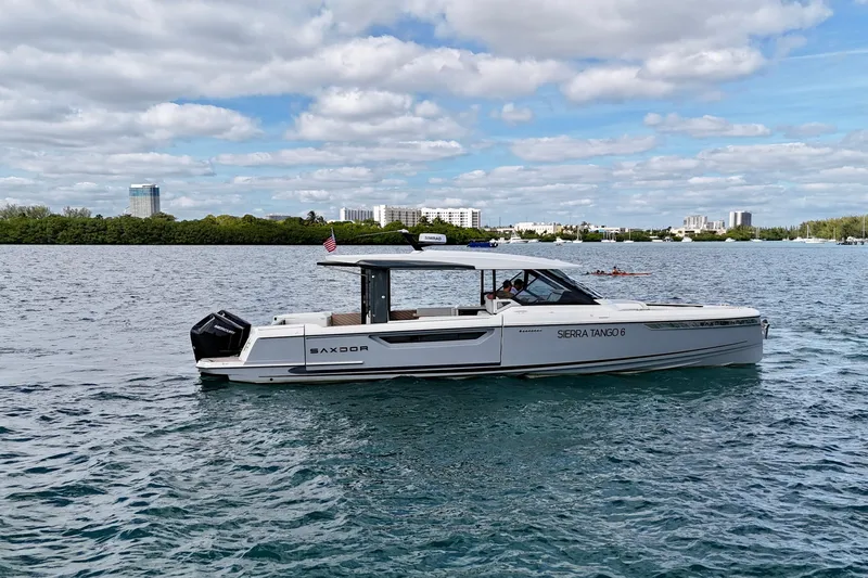 Sierra Tango VI Yacht Photos Pics 2025 Saxdor 400 GTO boat cruising on a scenic waterway under a partly cloudy sky.