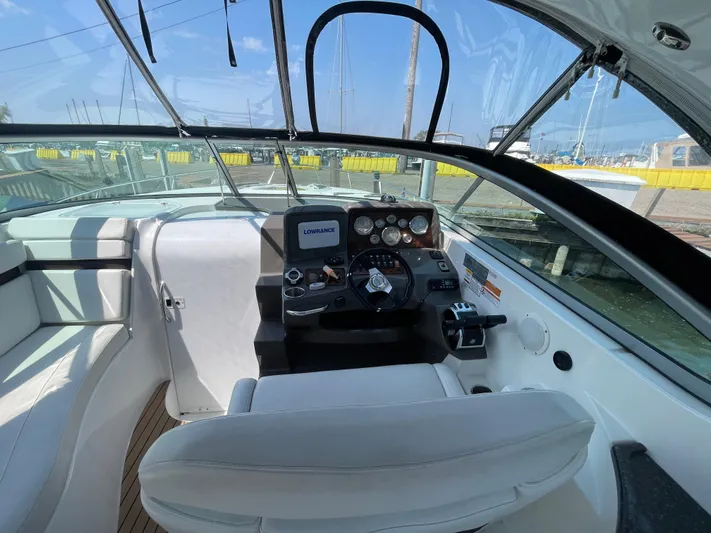  Yacht Photos Pics 2013 Rinker 310 Express Cruiser cockpit with steering wheel and navigation system.
