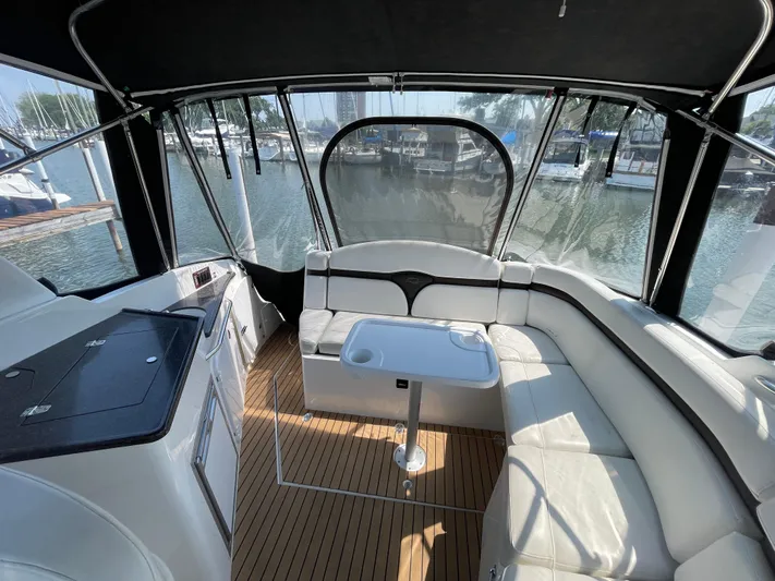  Yacht Photos Pics 2013 Rinker 310 Express Cruiser interior with white seating and table, docked at marina.