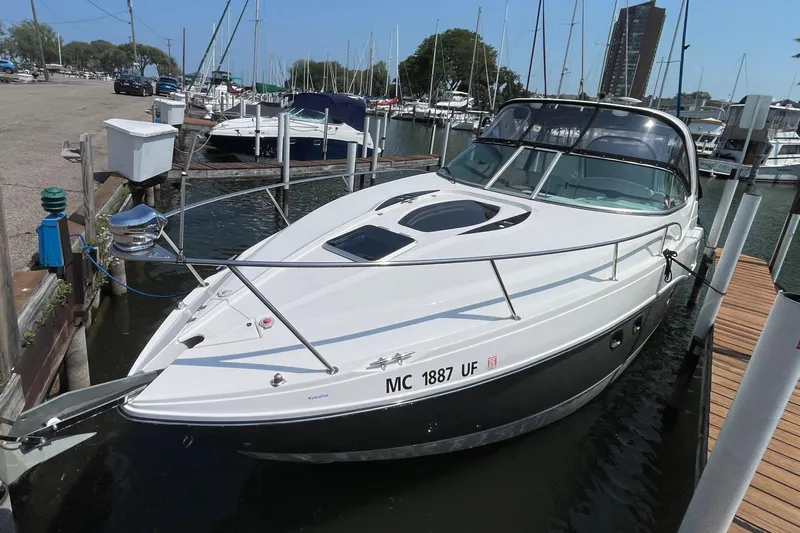  Yacht Photos Pics 2013 Rinker 310 Express Cruiser docked at a marina, surrounded by other boats.