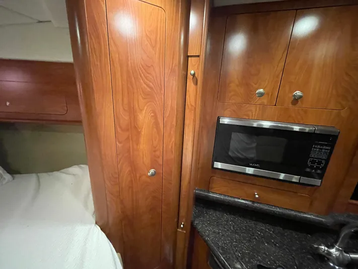  Yacht Photos Pics 2013 Rinker 310 Express Cruiser interior with wood cabinetry and microwave.