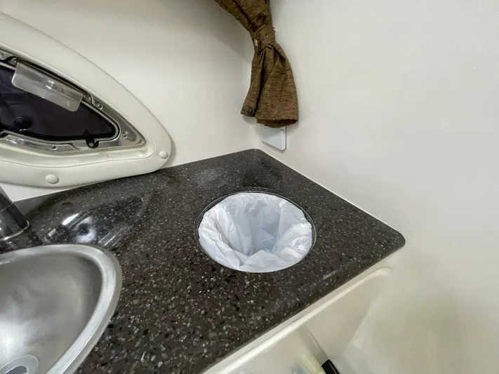  Yacht Photos Pics 2013 Rinker 310 Express Cruiser interior with sink and countertop waste bin.