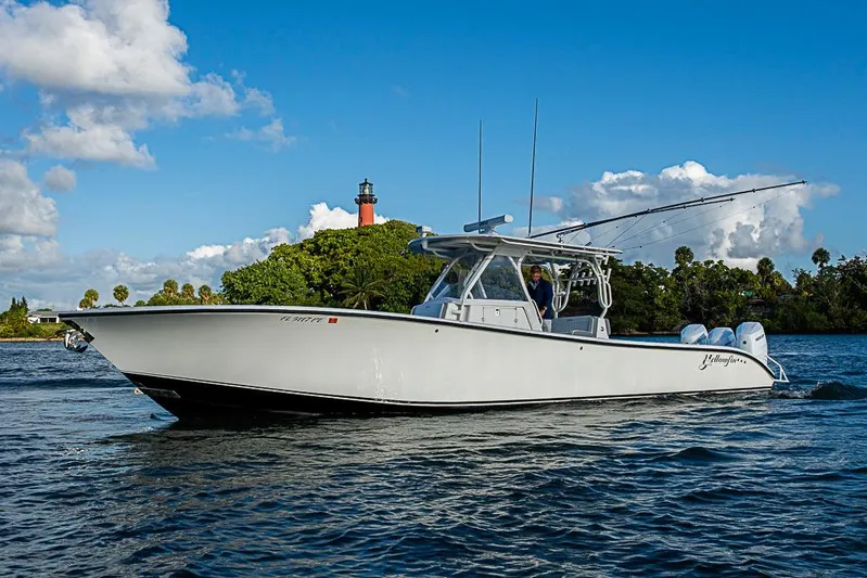 Quest Yacht Photos Pics 2011 Yellowfin 39 Offshore boat cruising near a scenic lighthouse.