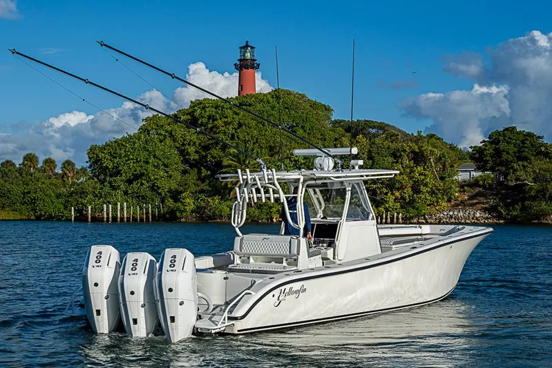 Quest Yacht Photos Pics 2011 Yellowfin 39 Offshore boat with triple engines near a lighthouse.