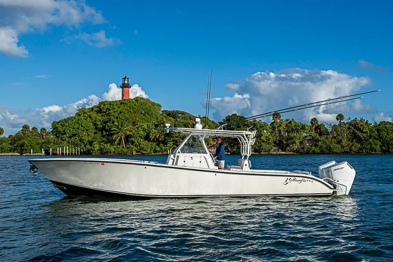 Quest Yacht Photos Pics 2011 Yellowfin 39 Offshore boat on water near lush island and lighthouse.