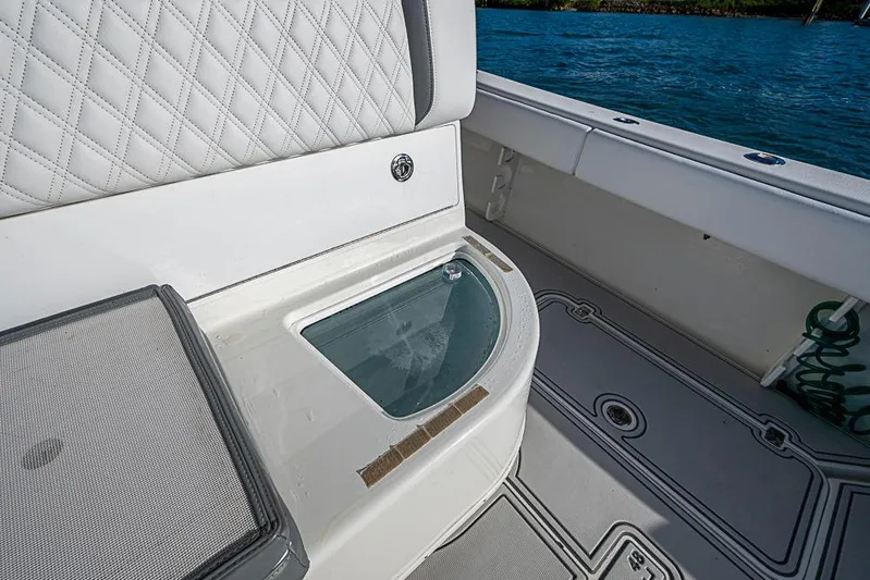 Quest Yacht Photos Pics 2011 Yellowfin 39 Offshore boat interior with cushioned seating and storage compartment.