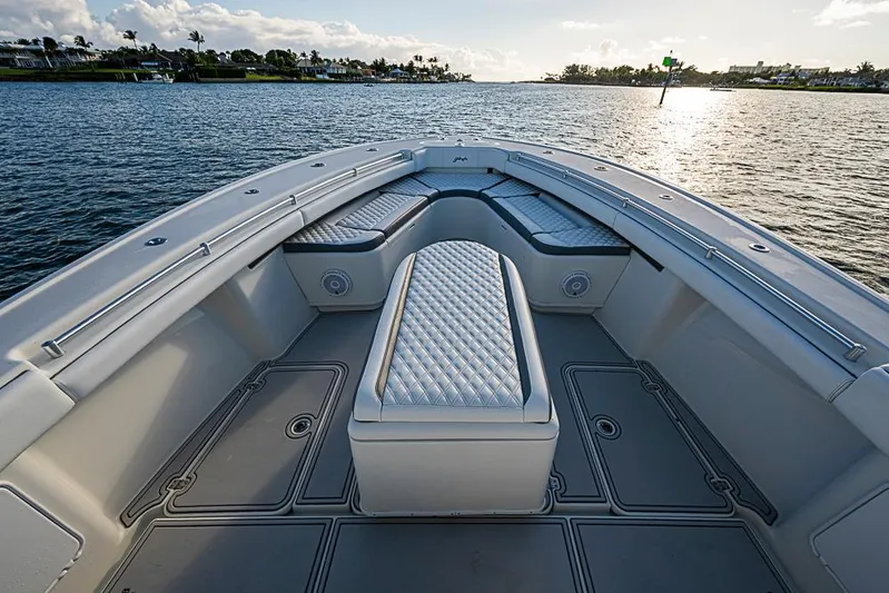 Quest Yacht Photos Pics 2011 Yellowfin 39 Offshore boat interior with cushioned seating, on calm water at sunset.