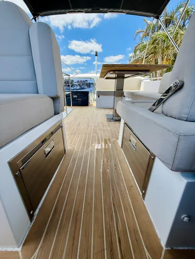 La Vida Boca Yacht Photos Pics 2019 Sealine F430 yacht interior with sleek seating and wooden flooring under a blue sky.