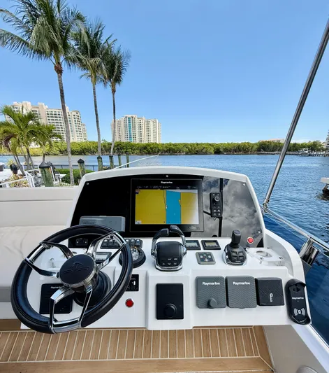 La Vida Boca Yacht Photos Pics Helm of 2019 Sealine F430 yacht with navigation controls, overlooking waterfront and palm trees.