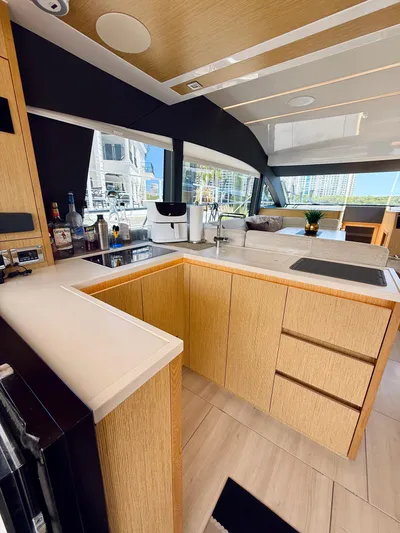 La Vida Boca Yacht Photos Pics Modern kitchen interior of 2019 Sealine F430 yacht with sleek wood cabinetry and large windows.