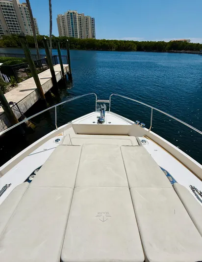 La Vida Boca Yacht Photos Pics 2019 Sealine F430 yacht bow with sunbed, docked by waterfront buildings.