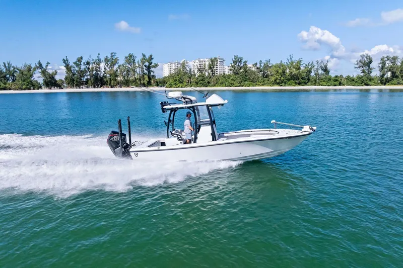  Yacht Photos Pics 2020 Barker Boatworks 26 Open cruising on clear blue water near a lush shoreline.