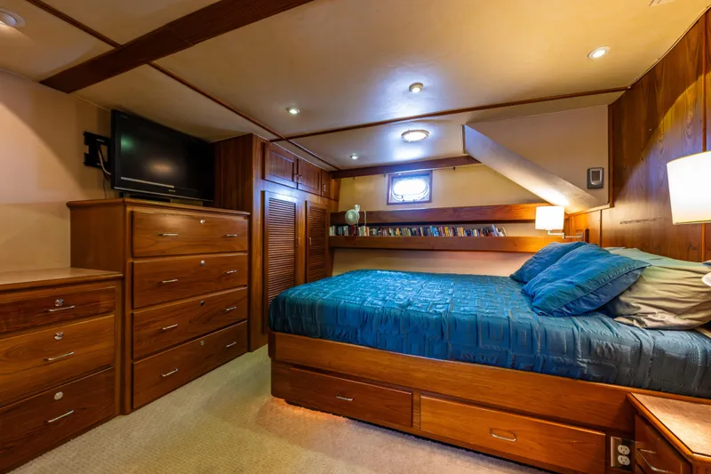 Traveller II Yacht Photos Pics Luxurious 2001 Rodriquez Pilothouse bedroom with wood furnishings and cozy bedding.
