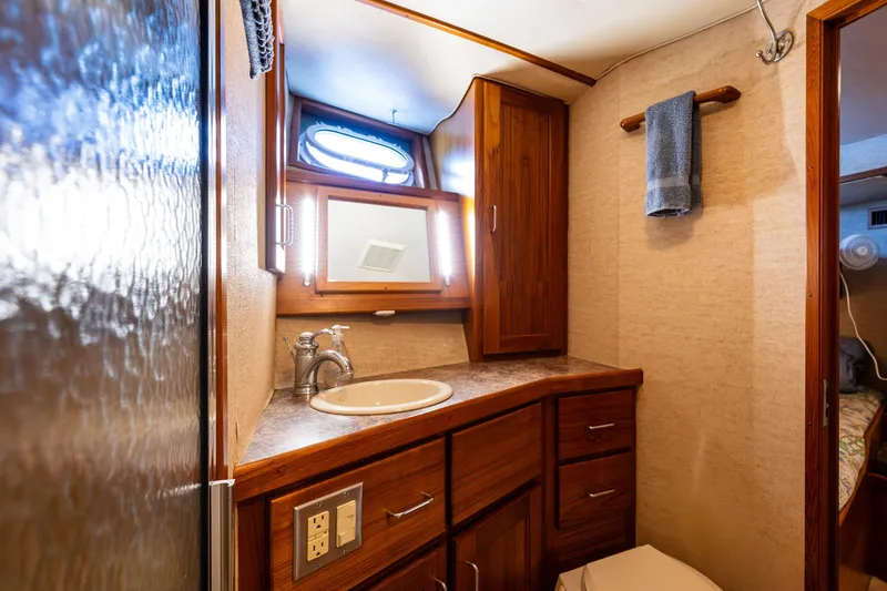 Traveller II Yacht Photos Pics Luxurious 2001 Rodriquez Pilothouse bathroom with wooden cabinetry and modern fixtures.
